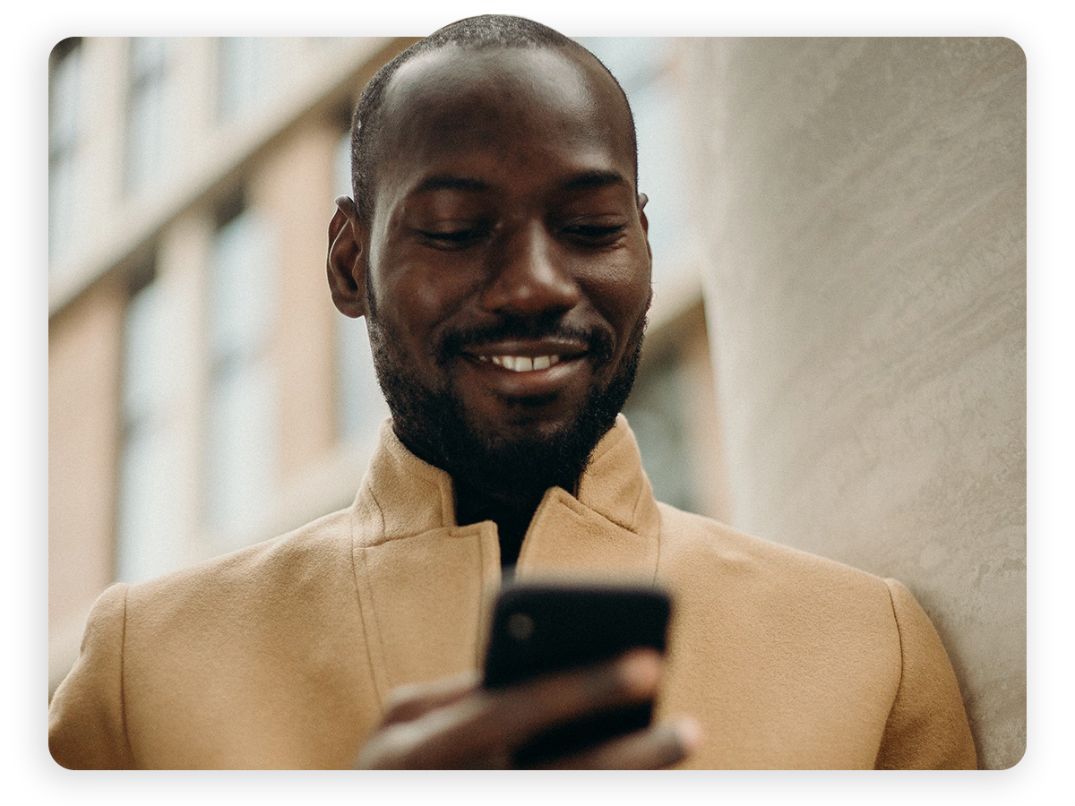 A man smiling at his phone